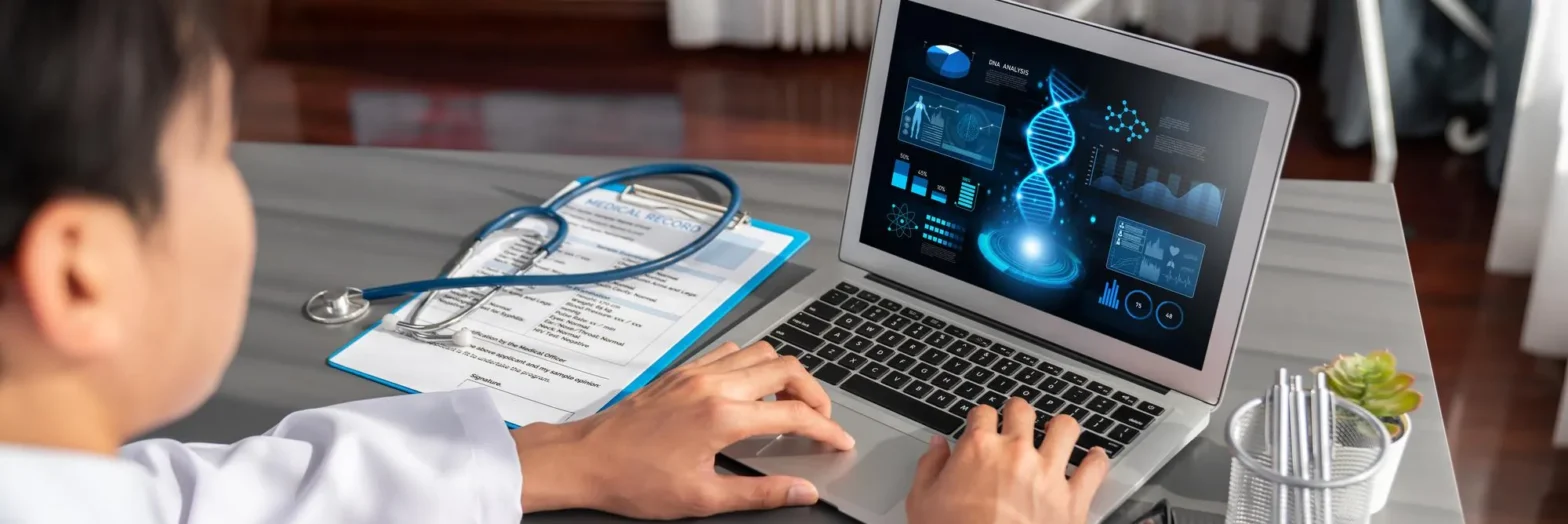 Healthcare professional reviewing electronic medical records and insurance information on a laptop to complete prior authorization for medication before prescription approval.