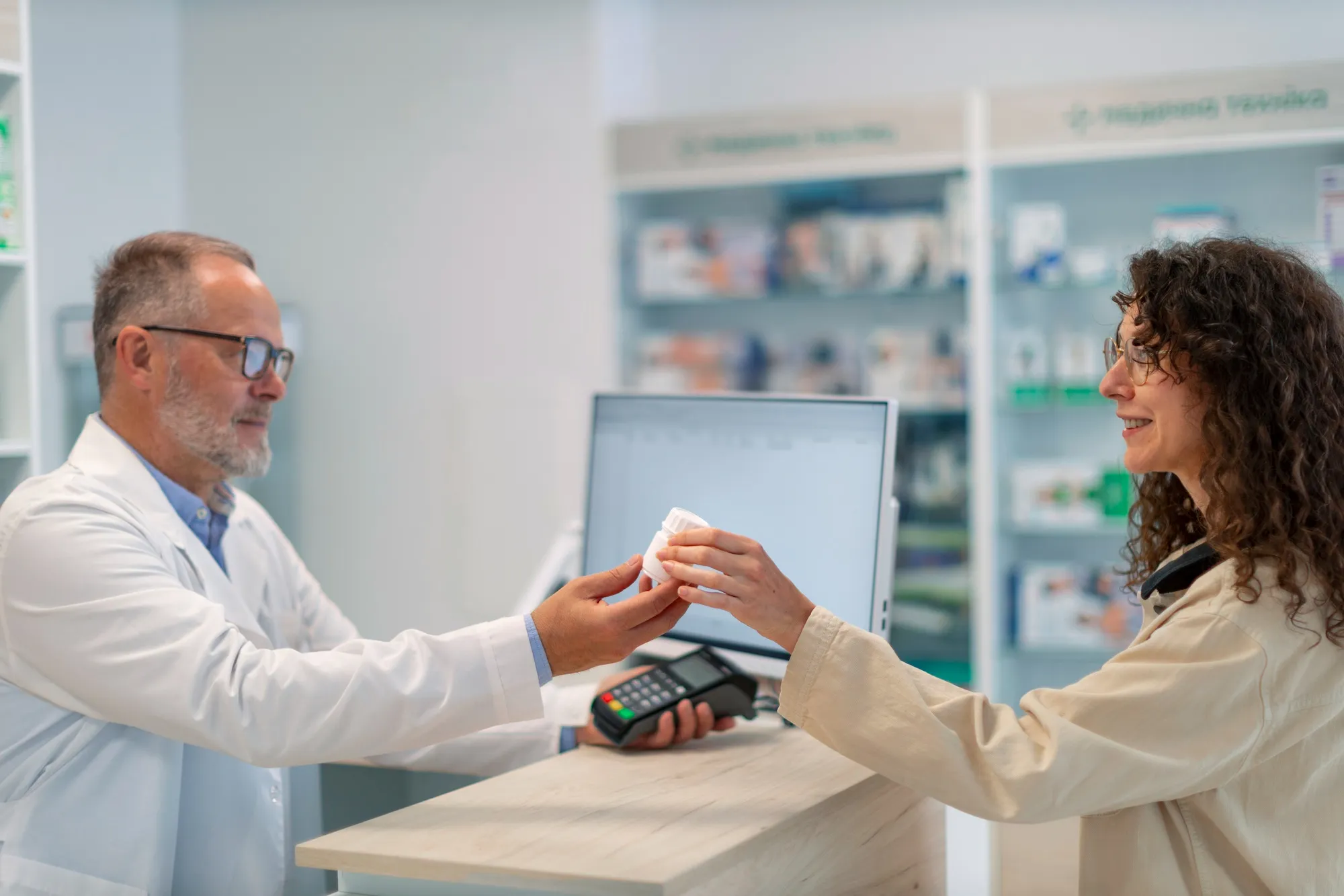 Pharmacist providing medication to a patient with EPA Assistance for Pharmacies and ePA services.