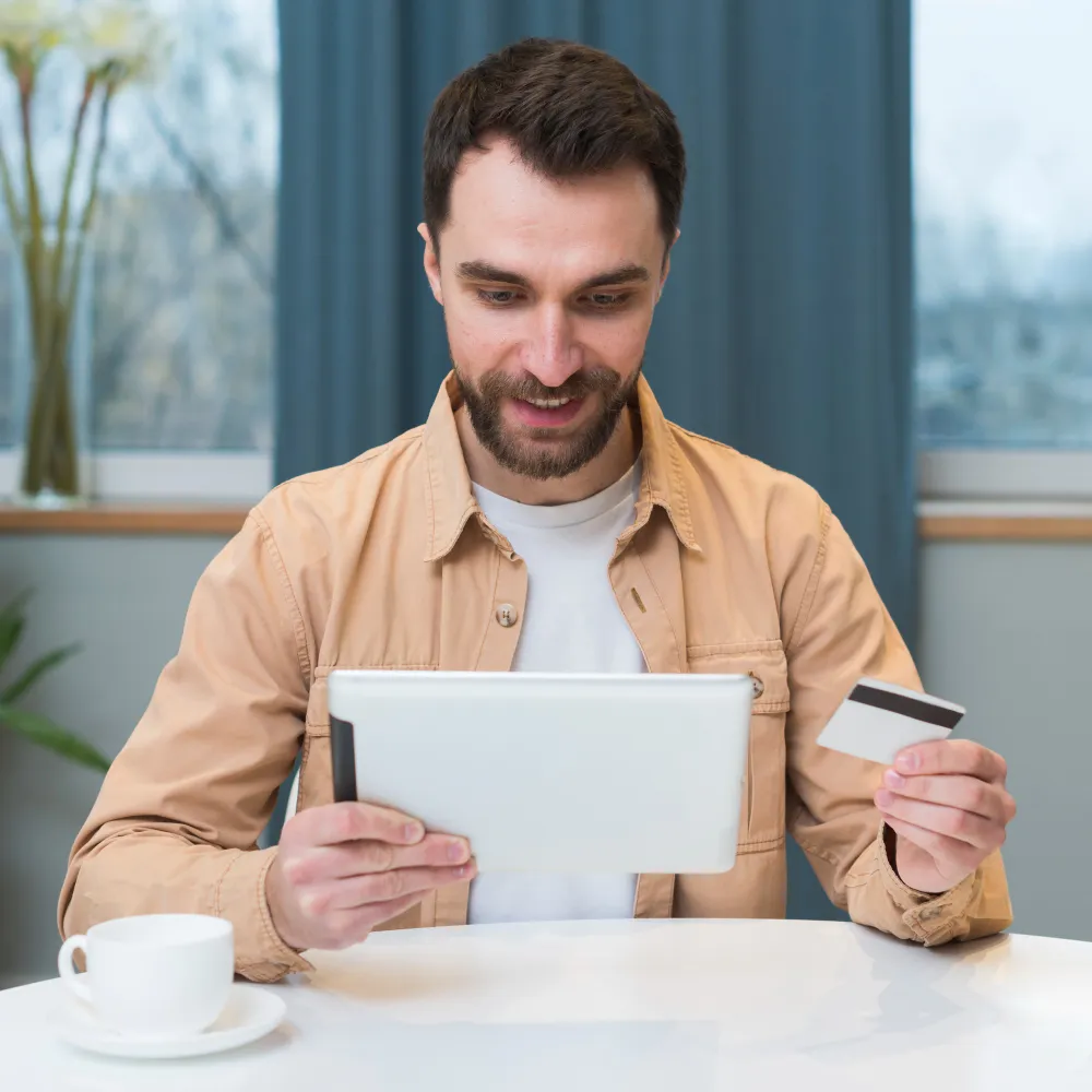 Individual using a tablet and payment card, illustrating digital efficiency and cost transparency enabled by prior authorization automation and improved prior authorizations for payors