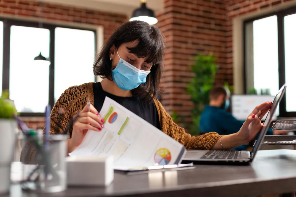 A professional reviewing reports on a laptop, highlighting advanced PA solutions in healthcare and secure healthcare data management solutions for improved operational efficiency