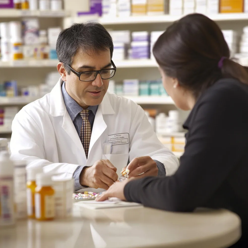 Pharmacist consulting a patient with medications, highlighting medication authorization services for pharmacies and integrated prescription management