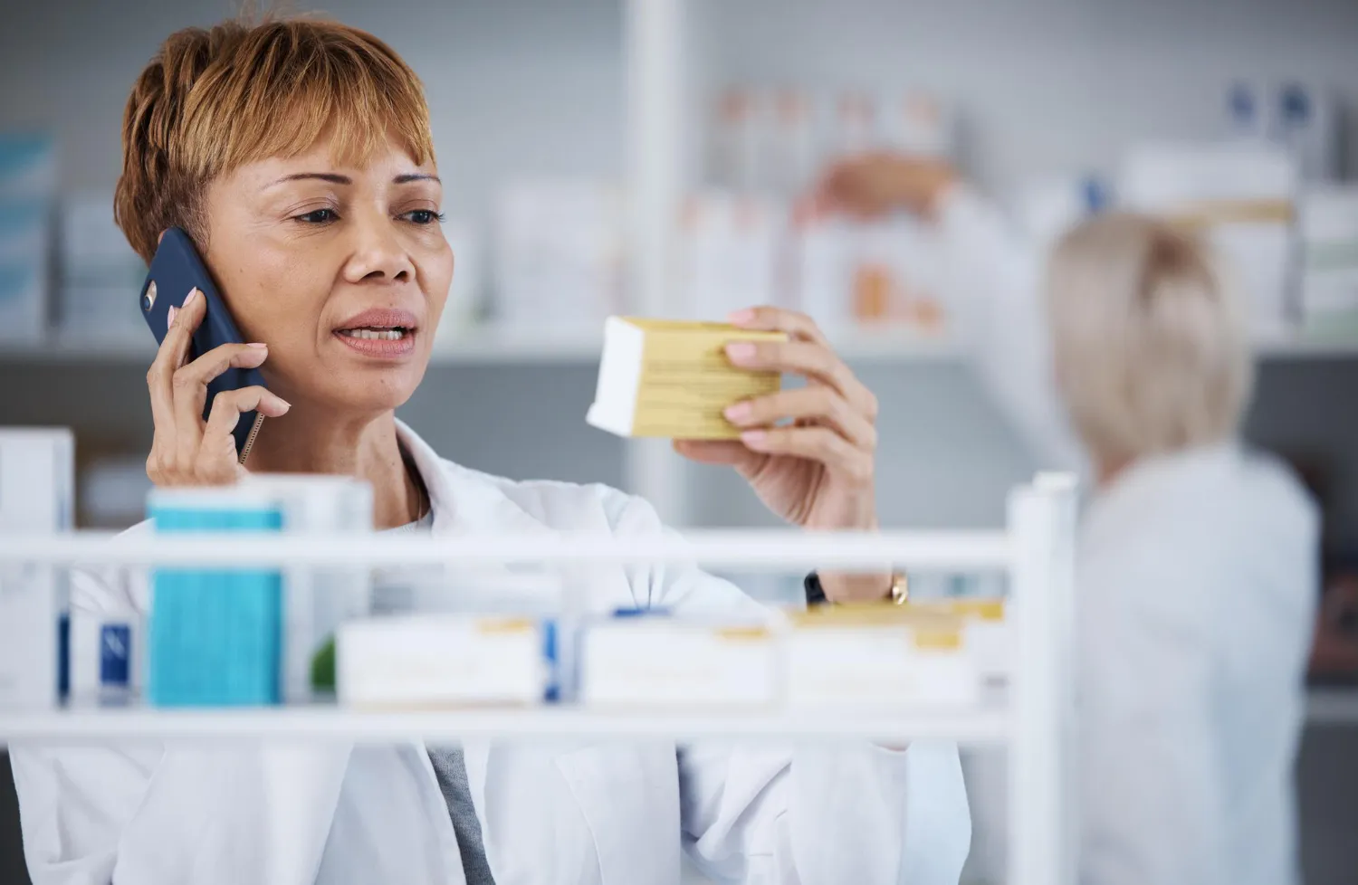 Pharmacist reviewing medication details while on a call, representing efficient prior authorization for medication and real-time coordination through advanced prior authorization solutions