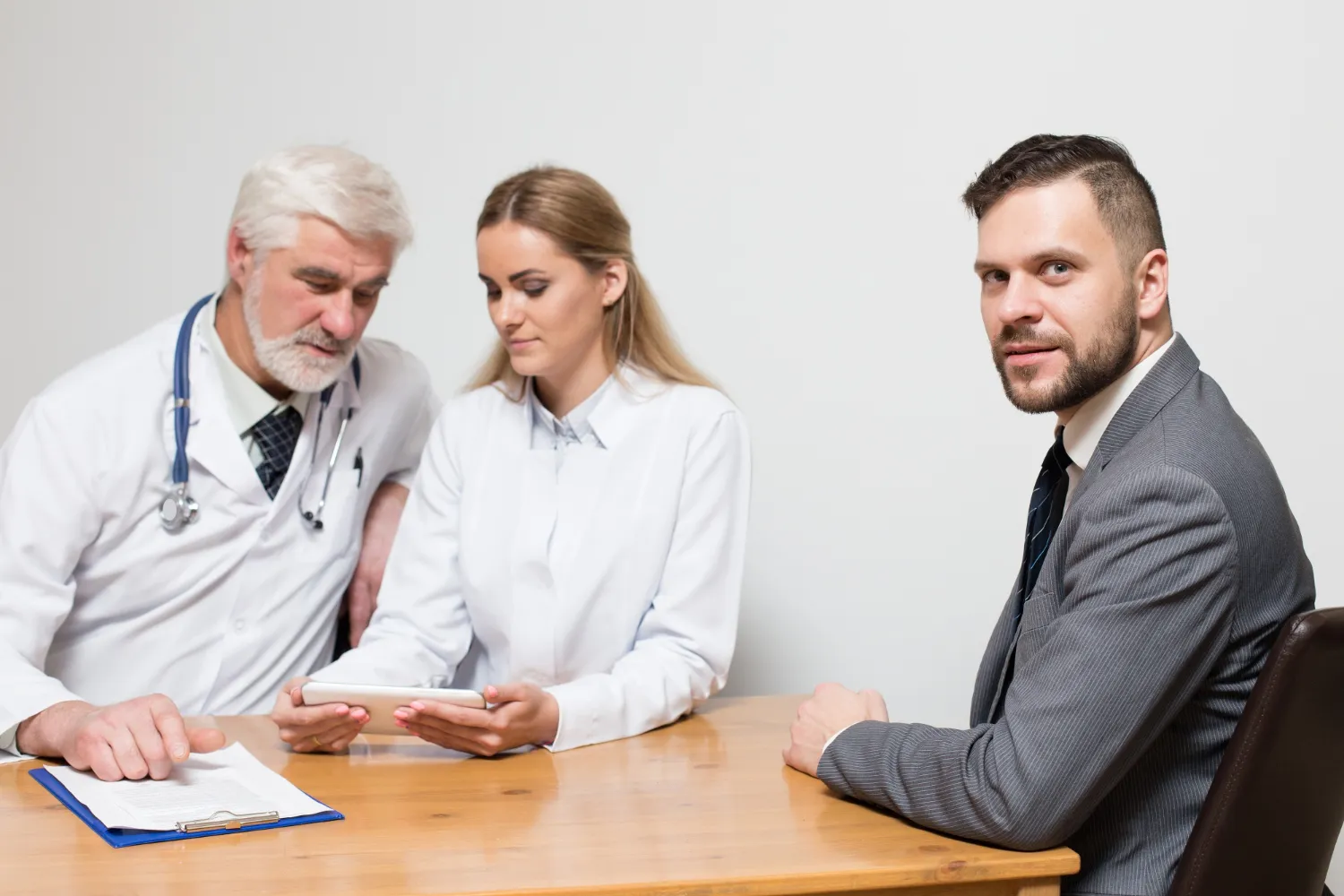 Doctors and a patient reviewing prescription plans together, highlighting Prescription Assistance Programs for Patients and improving Patient Access to Prescription Medications